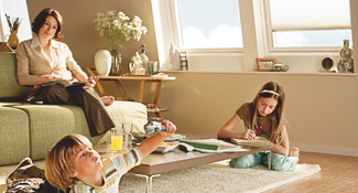 Mother reading whilst children play